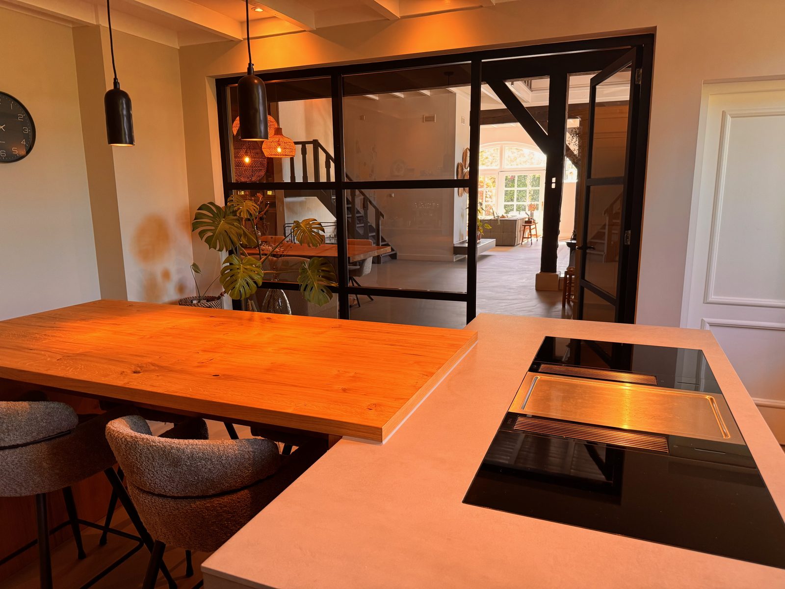 Moderne keuken met houten kookeiland en zwarte stalen deuren